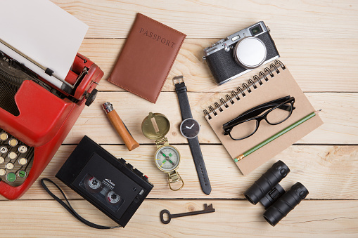 Writer or journalist workplace - vintage red typewriter, photo camera, cassette recorder on the wooden desk