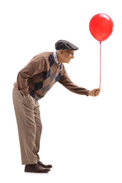 istock Senior man handing a red balloon 1153725495