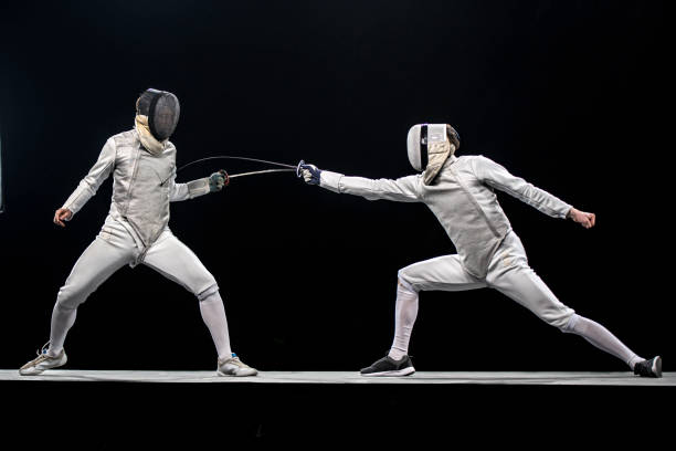 two fencers fighting in front of a black background - fencing sport rivalry sword imagens e fotografias de stock