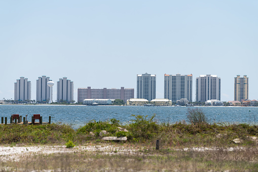 Cityscape, skyline of Navarre beach city town on Pensacola bay pcean sea coast shore with many high-rise apartment condo condominium buildings towers in Florida Panhandle
