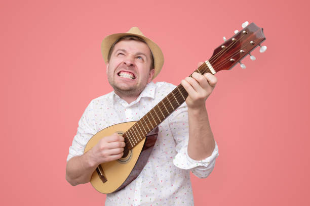 istock Man in summer hat playing guitar and singing songs. 1153730844