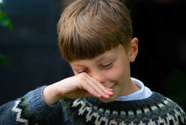 Boy rubbing his nose.