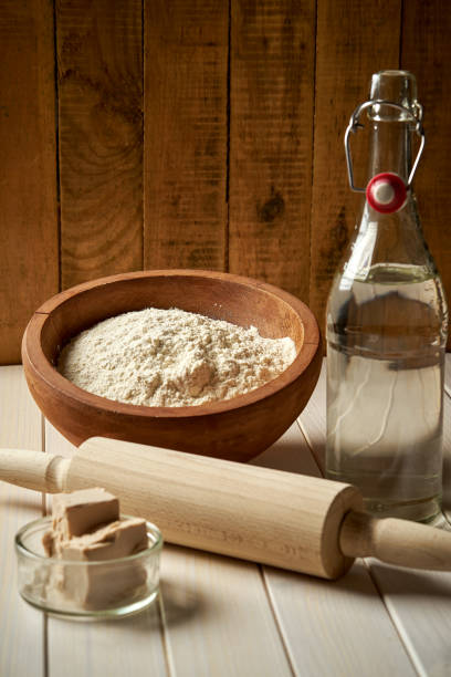 istock Ingredients for dough on pastry board with flour and rolling pin on table 1153734809