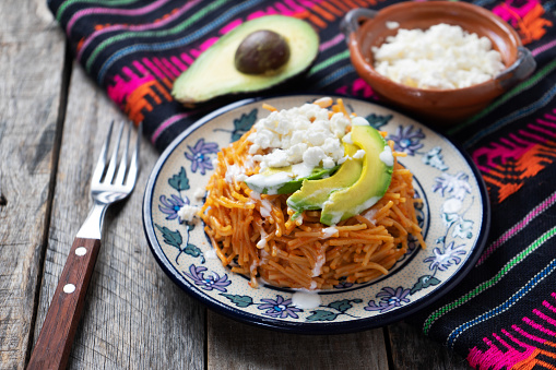 Tasty mexican fideos dry soup with avocado and cheese