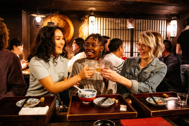 istock Three women toasting drinks in Japanese restaurant 1153738780