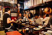Group of friends ordering food in Japanese Izakaya