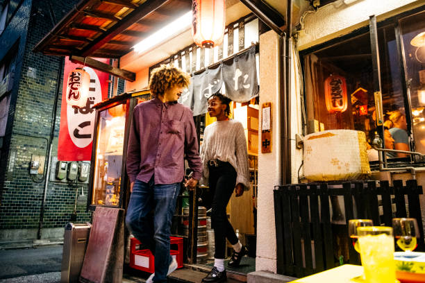 istock Attractive young couple leaving restaurant holding hands 1153738792