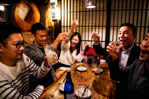 colegas de trabalho no restaurante japonês que brindam bebidas - somente japonês - fotografias e filmes do acervo