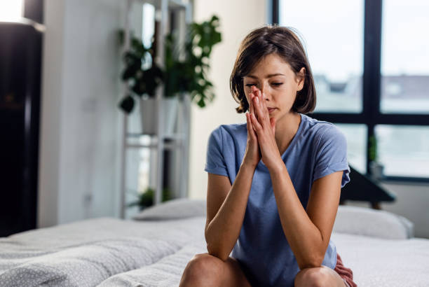istock Young thoughtful woman alone sitting on the bed. 1153739394