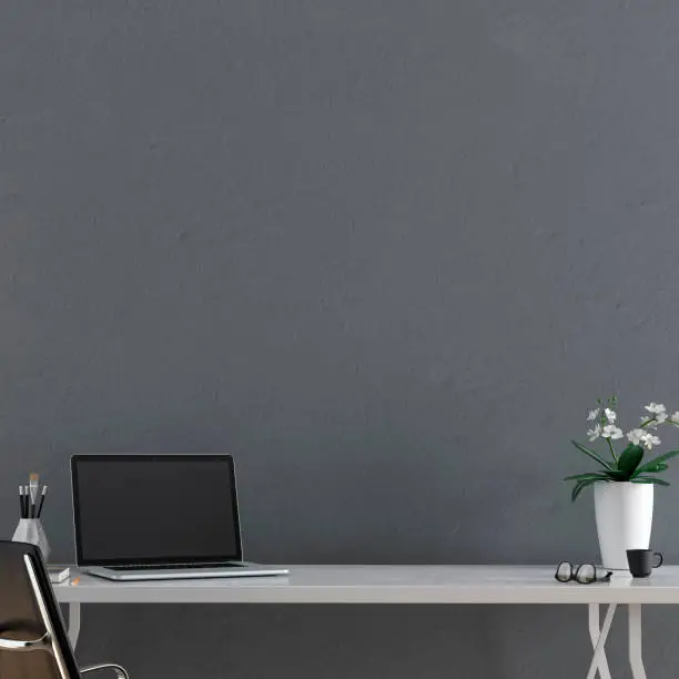 Workdesk with decoration in front of empty grey plaster wall with copy space. 3D rendered image.