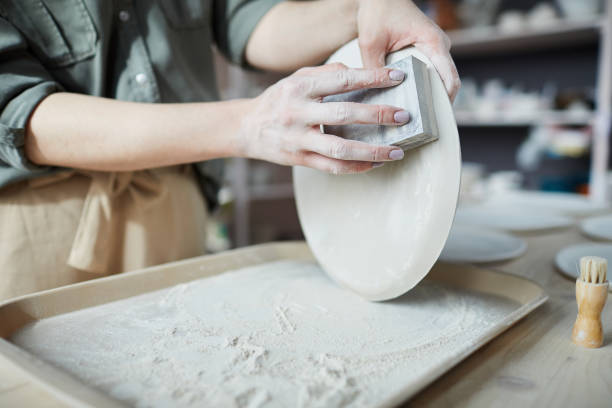 istock Female Ceramist Sanding Plates 1153741643