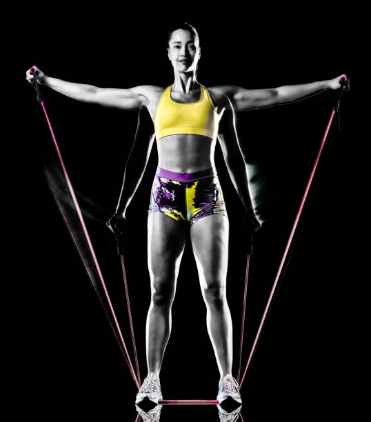 woman exercising fitness exercises isolated black background lightpainting effect one mixed race woman exercising fitness exercises isolated on black background with lightpainting effect multiple exposures lightpainting stock pictures, royalty-free photos & images