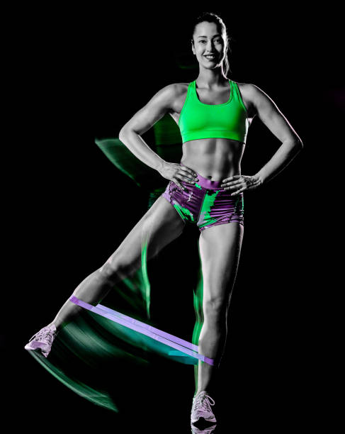 woman exercising fitness exercises isolated black background lightpainting effect one mixed race woman exercising fitness exercises isolated on black background with lightpainting effect lightpainting stock pictures, royalty-free photos & images
