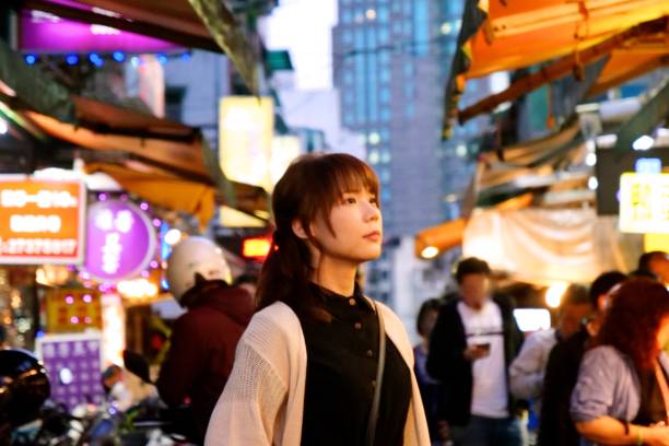 istock Young woman walking at night market 1153752242