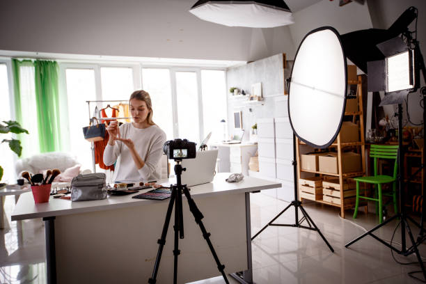 istock Young female vlogger in front of video camera at her studio 1153753818
