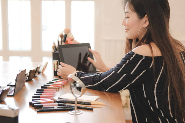 istock asian woman applying makeup cosmetic 1153753982