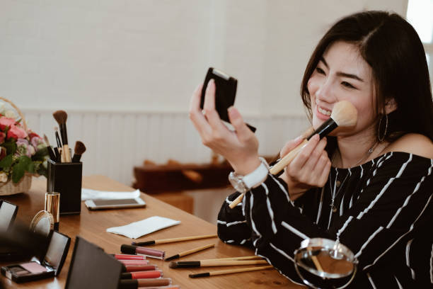istock asian woman applying makeup cosmetic 1153753986