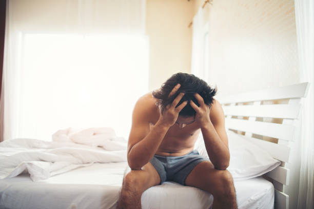 istock Worried man sitting on bed in the morning, serious thinking something 1153754304
