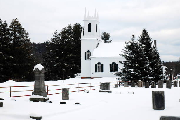 Guilford, VT, USA February 16, 2010 A classic white church and the graveyard stands silently under a blanket of snow