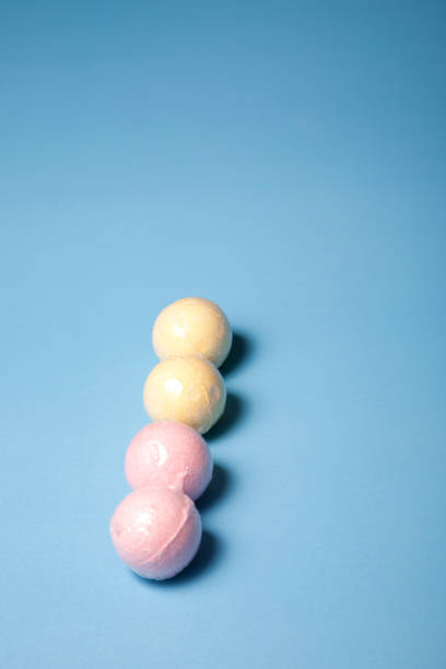 istock Four pink and yellow bath bombs in a row 1153756652