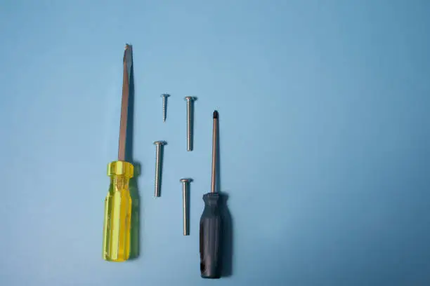 Lay flat view of tools including screws, nails, a hex key and screwdrivers