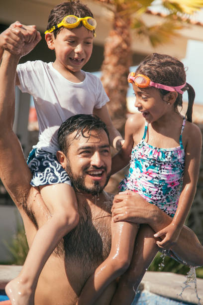 istock Mexican dad playing with kids in the pool 1153761322