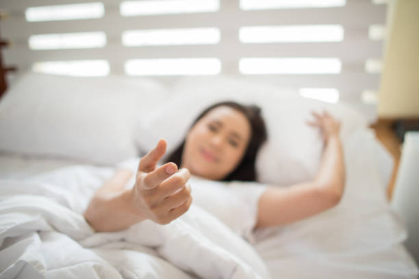 Happy woman on the bed and invited her boyfriend make something stock photo