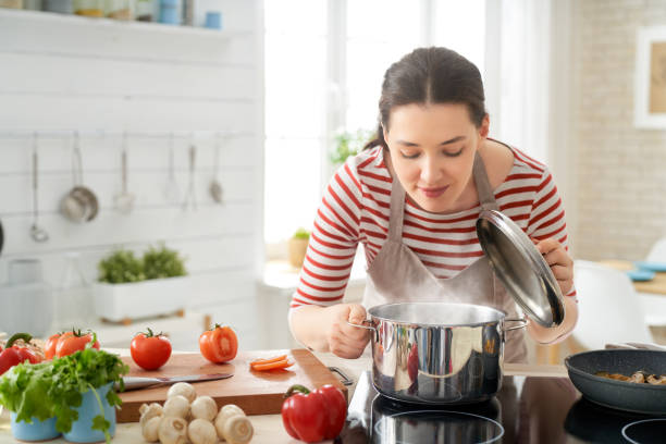 woman is preparing proper meal - cozinhar imagens e fotografias de stock