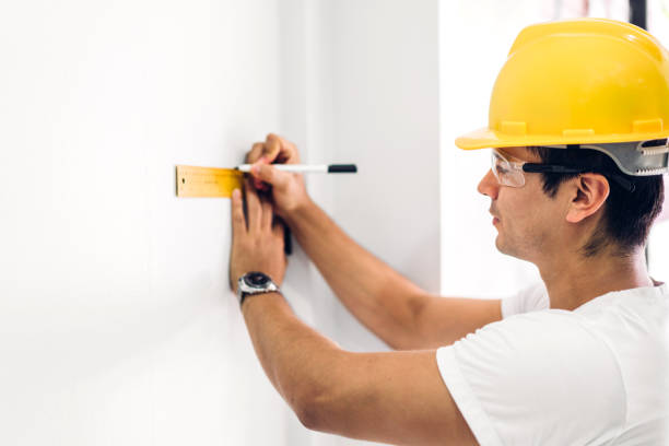 istock Young construction engineer in a yellow helmet working and  looking job for planning project at building home site 1153775608