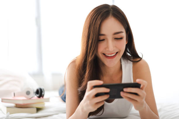 istock Happy woman relaxing using and talking by smartphone on the bed at home.technology and communication concept 1153776359