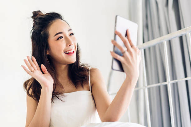 istock Happy woman relaxing using tablet computer on the bed at home.technology and communication concept 1153776446