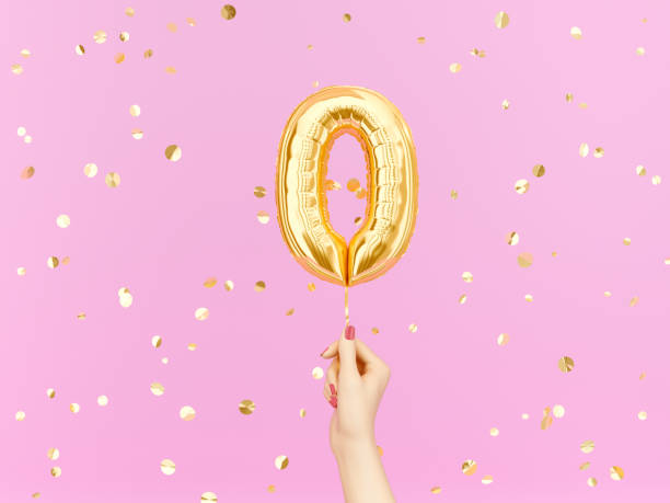 istock Zero on pink. Female hand holding Number 0 foil balloon 1153776453