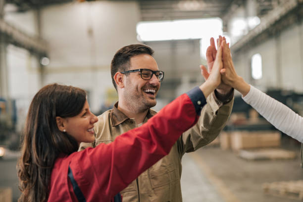 istock Positive industrial factory workers group giving high five. 1153781533