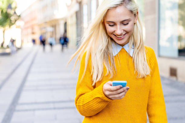 Happy woman walking and texting