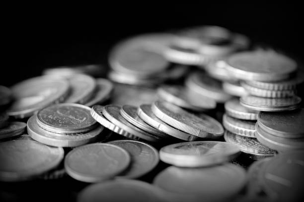 istock Euro coins scattered on a dark surface close up. Black and white 1153788100