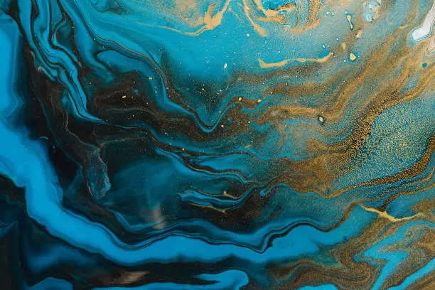 Photo of Acrylic Fluid Art. Blue aquamarine waves and gold inclusion. Abstract marble background or texture