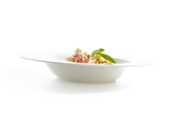 Italian Penne Pasta with Bacon, Blue Cheese, Sauce, Onion, Chicken Fillet, Garlic, Cream, Parsley, Parmesan Cheese Top View. Traditional Homemade Italian Macaroni Isolated on White Background
