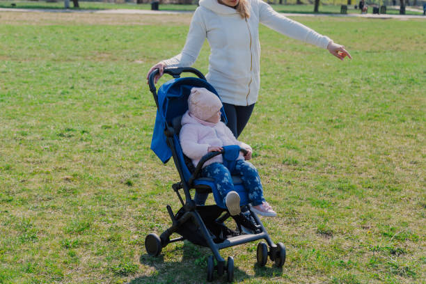 istock Young mother with a baby in a stroller in a summer park 1153794755