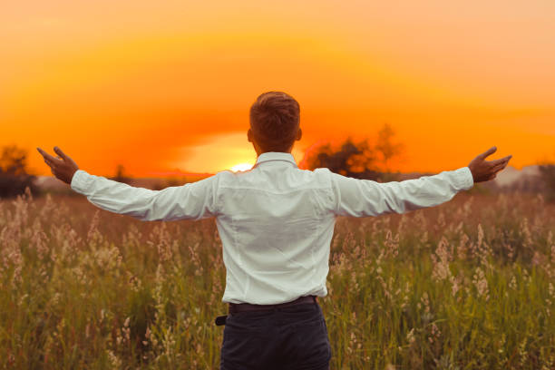 istock a man raises his hands to the sun 1153795048