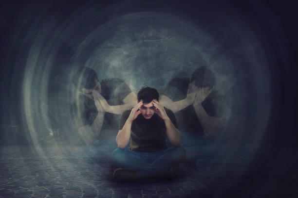 Man seated on the floor, hands to head, suffer split emotions into different inner personalities. Multipolar mental health disorder. Schizophrenia psychiatric disease. Man seated on the floor, hands to head, suffer split emotions into different inner personalities. Multipolar mental health disorder. Schizophrenia psychiatric disease. Dementia reactions mood change. schizophrenia photos stock pictures, royalty-free photos & images