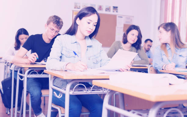 istock Smiling schoolgirl is learning and answering the question on paper 1153796020