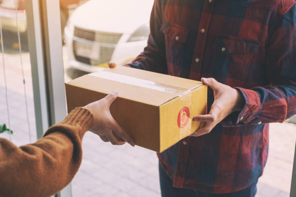 istock woman receiving parcel box from delivery man 1153796216