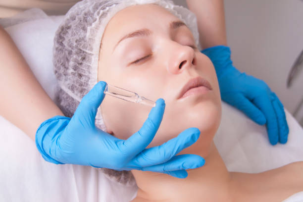 Cosmetic ampoule, a woman in the beauty salon. Vitamin in cosmetic ampoule. - fotografia de stock