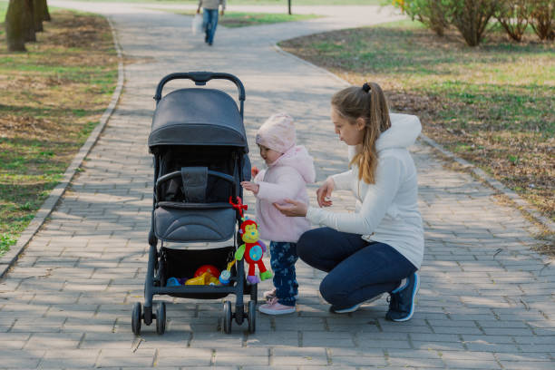 istock A young mother walks with a child who rolls a pram 1153798266