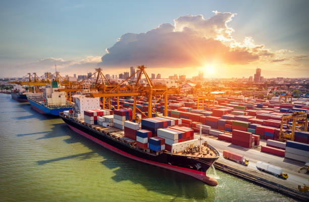 istock Logistics and transportation of Container Cargo ship and Cargo plane with working crane bridge in shipyard at sunrise, logistic import export and transport industry background 1153798401