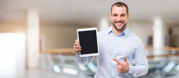 Man in the business center with tablet Happy man in the business center with tablet business person one man only blue standing stock pictures, royalty-free photos & images