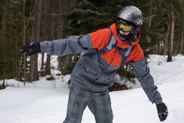Snowboarder moves down the ski slope. Rest in a ski resort. Young man moves down a ski slope on a snowboard. bukovel ski resort ukraine stock pictures, royalty-free photos & images