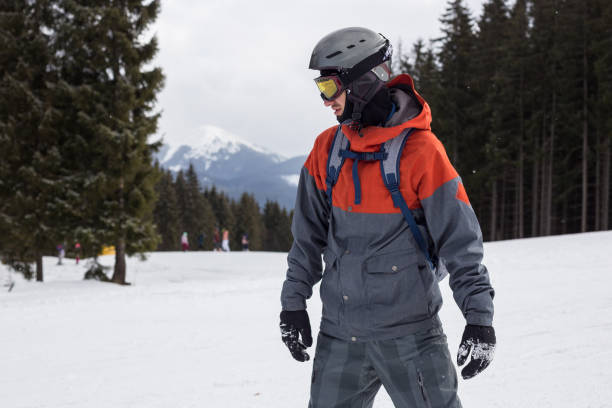 Snowboarder moves down the ski slope. Rest in a ski resort. Young man moves down a ski slope on a snowboard. bukovel ski resort ukraine stock pictures, royalty-free photos & images
