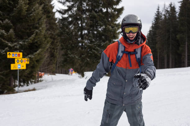 Snowboarder moves down the ski slope. Rest in a ski resort. Young man moves down a ski slope on a snowboard. bukovel ski resort ukraine stock pictures, royalty-free photos & images