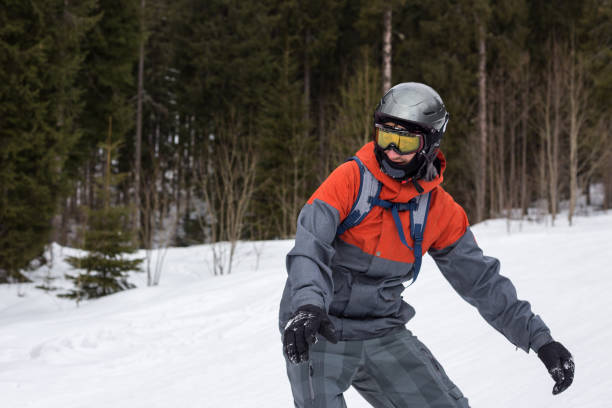Snowboarder moves down the ski slope. Rest in a ski resort. Young man moves down a ski slope on a snowboard. bukovel ski resort ukraine stock pictures, royalty-free photos & images